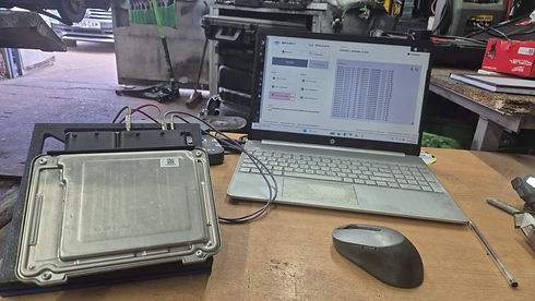 laptop on a table with a part of engine