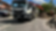 A construction truck is parked on a residential street beside a house