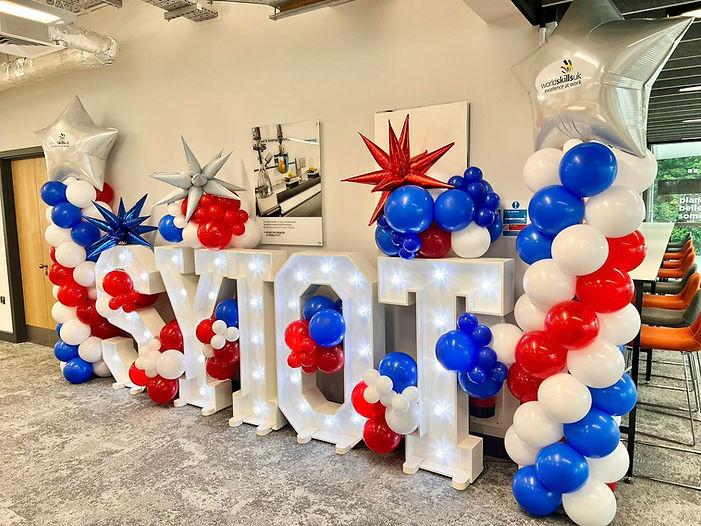 A large sign decorated with colorful balloons and stars