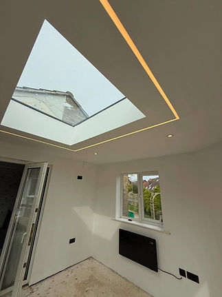 Modern minimalist room with a large skylight, recessed lighting, and white walls_