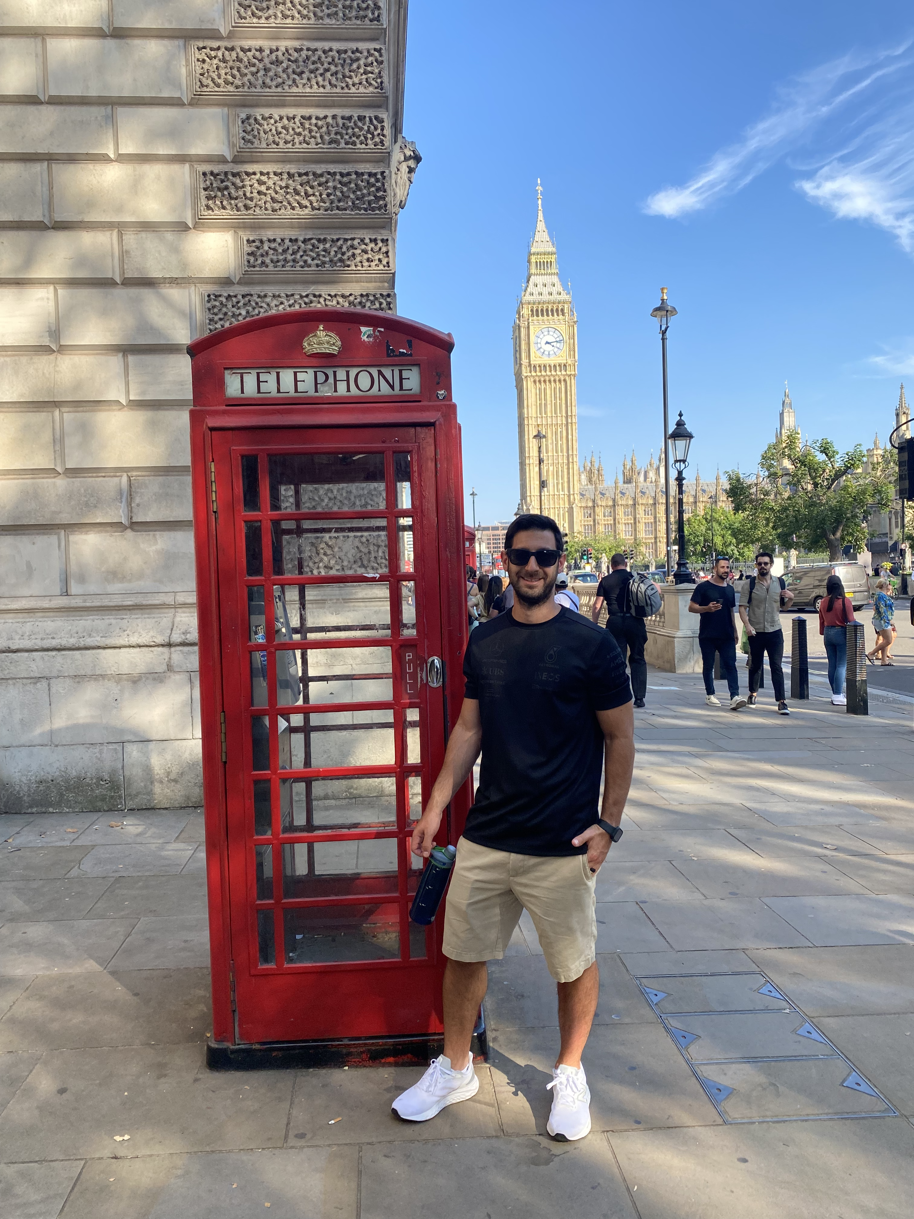 Man standing near a phone booth.