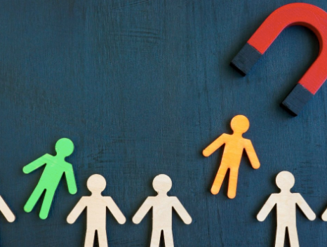Red magnet attracts orange figure; other figures are beige and green.