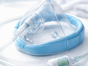 Clear oxygen mask with blue padding and attached tubing. 