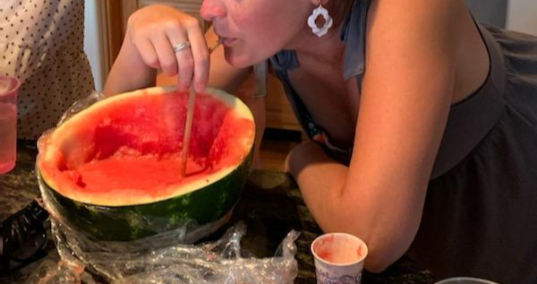 Woman enjoying watermelon juice with a straw
