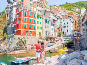 Couple looking at colorful hillside houses in Cinque Terre Italy.
