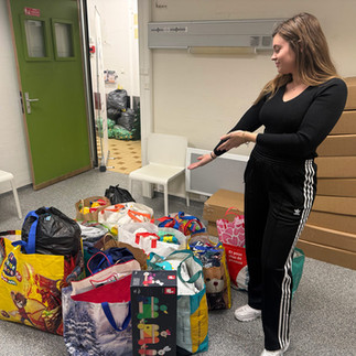 Femme devant sacs des collectes solidaires