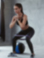 girl doing swuat with band and medicine ball