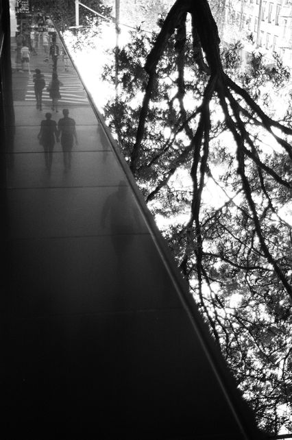 Black and white photography of an inverted reflection of pedestrians walking