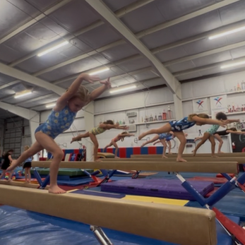 Gymnasts performing a lunge on balance beam