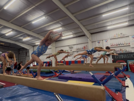 Gymnasts performing a lunge on balance beam