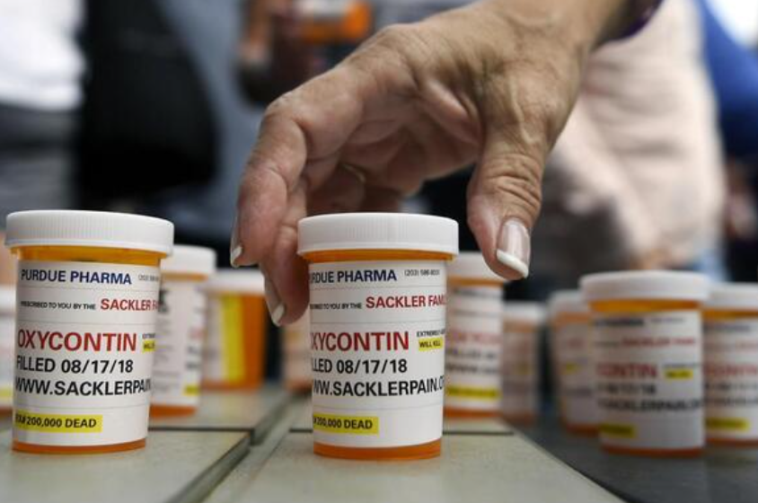 Family and friends who have lost loved ones to OxyContin and opioid overdoses leave pill bottles in protest outside the headquarters of Purdue Pharma, which is owned by the Sackler family, Aug. 17, 2018, in Stamford, Conn. (AP Photo/Jessica Hill, File)
