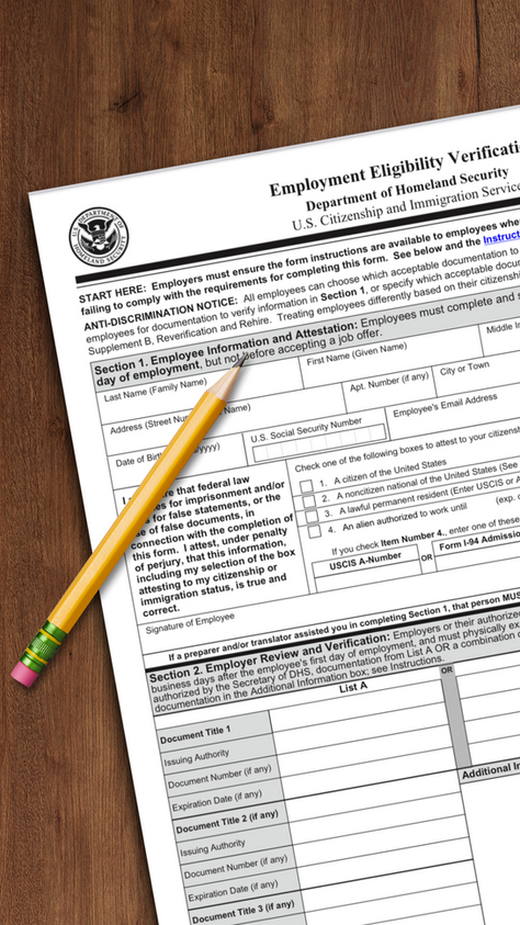 Close-up of a U.S. Citizenship and Immigration Services employment eligibility verification form with a pencil placed on top, symbolizing the importance of providing accurate information and the risks of falsifying details on U.S. student visa applications.