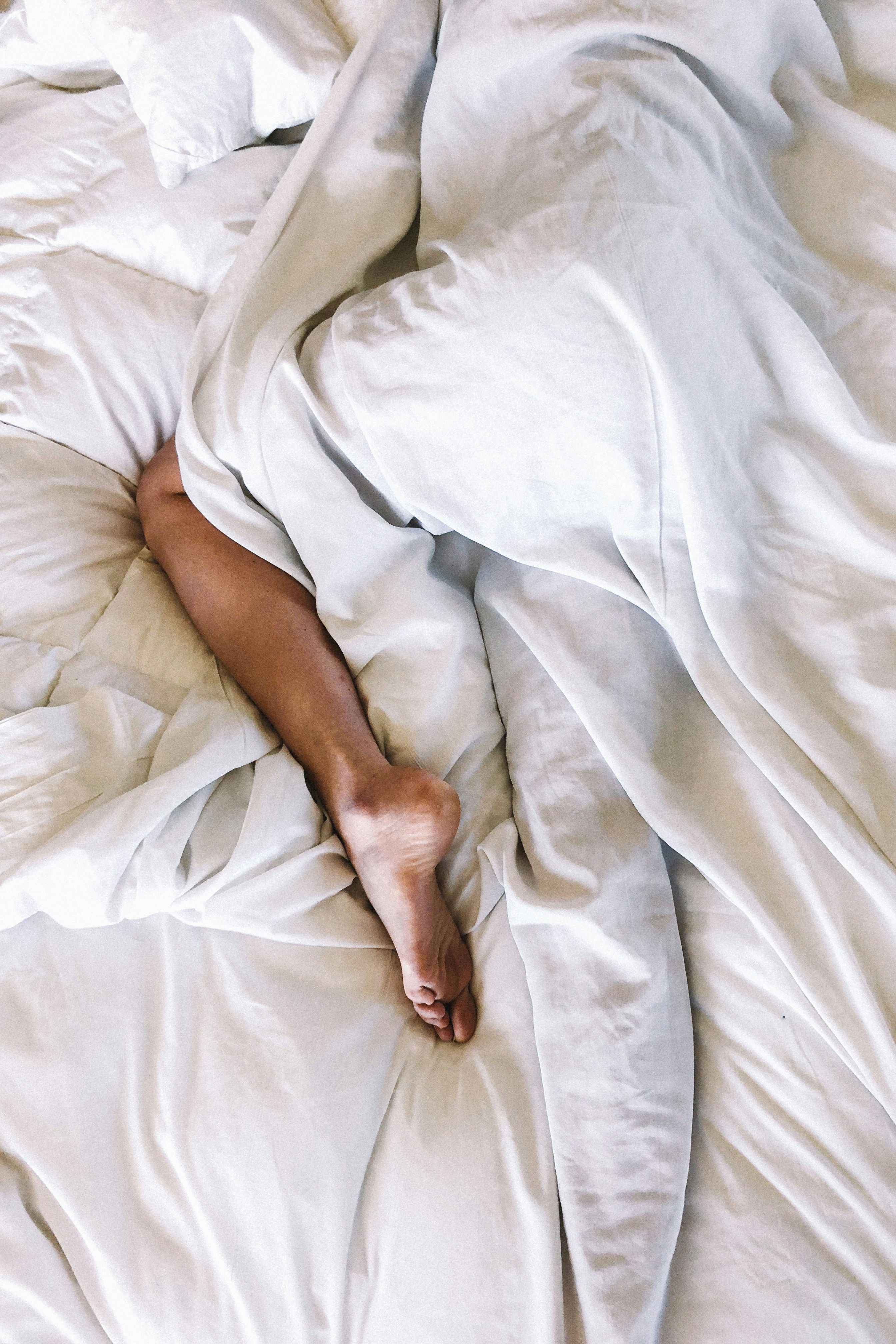 woman sleeping in white sheets