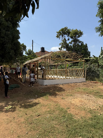A fully constructed Walipini frame made from intricate bamboo latticework stands completed, ready for cultivation, exemplifying the progress of the Walipini Impact in Uganda.	