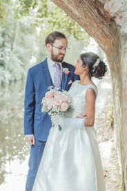 Bride and groom sharing a quiet moment under a stone bridge at Walton Hall.