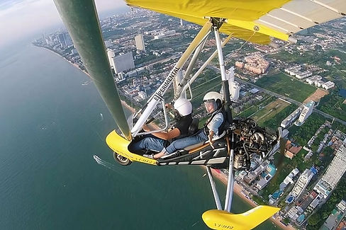 Microlight aircraft flying over Pattaya coastline during scenic sky tour.