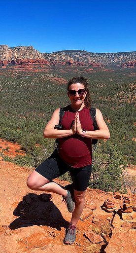 Woman in yoga tree pose on red rocks