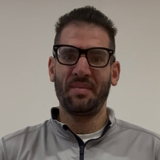 Headshot of a man with short dark hair, a beard, and glasses
