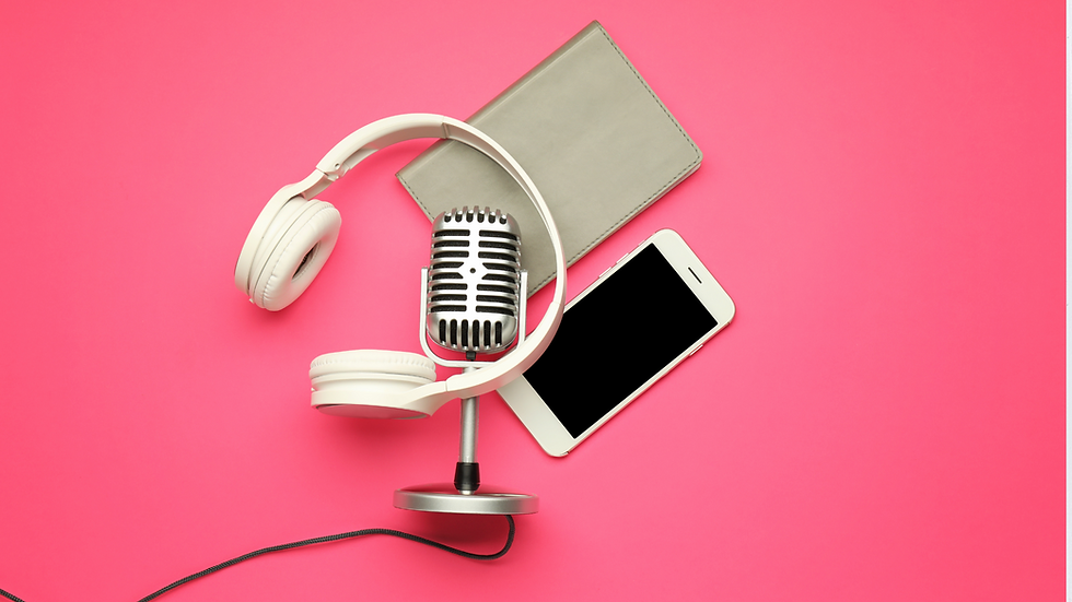 Silver microphone with white headphones, smartphone, and notebook on a vibrant pink background, suggesting a creative podcast setup.