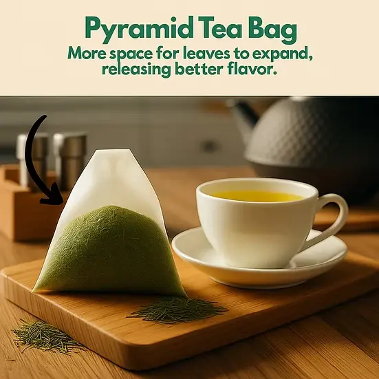 Plant-based pyramid tea bag filled with yerba mate leaves beside a golden cup of tea.