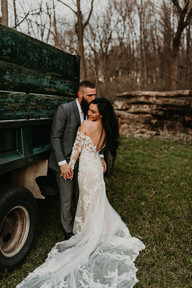 bride and groom snuggling by the side of the truck