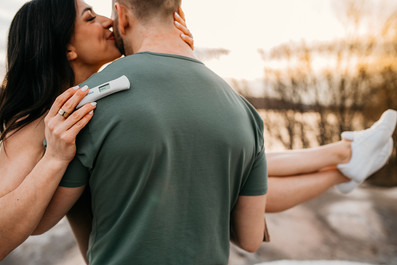 Dad holding mom while she kisses his cheek