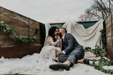 bride and groom kissing in back of truck