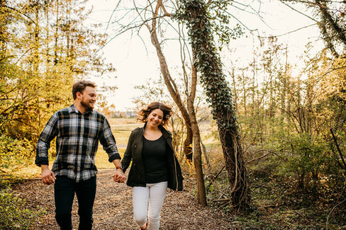 couple laughing while running in woods