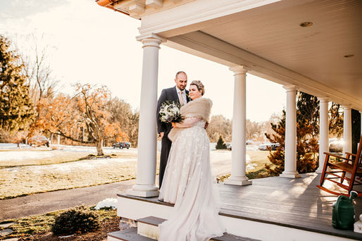 bride and groom standing on mansion porch