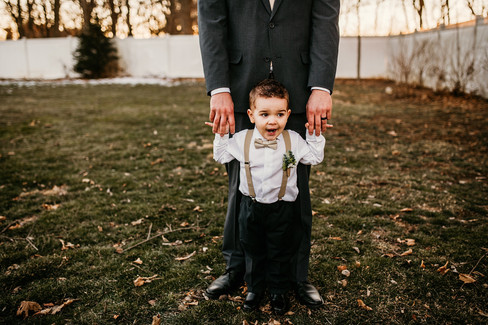 Groom holding son's hands