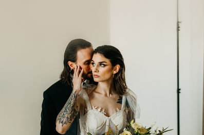 bride holding groom's face while looking off in distance