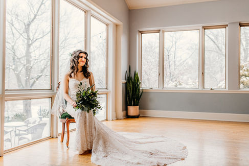 bride sitting in green velvet chair looking off to the side