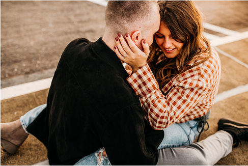 Couple snuggling on parking garage roof