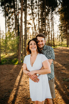couple hugging and smiling in woods