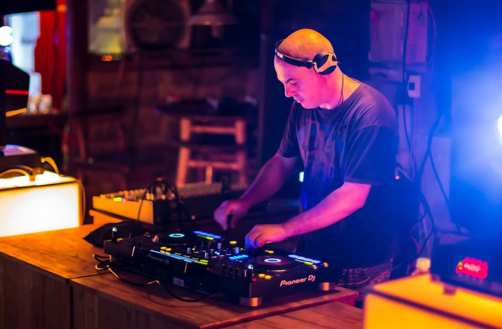 Marco Mei, an Italian DJ and producer, smiling over a crate of vinyl records in a record shop, including Getz/Gilberto and Herbie Hancock albums.