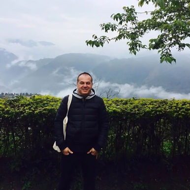 Marco Mei, Italian DJ and producer, standing in a lush mountainous landscape in Taiwan.