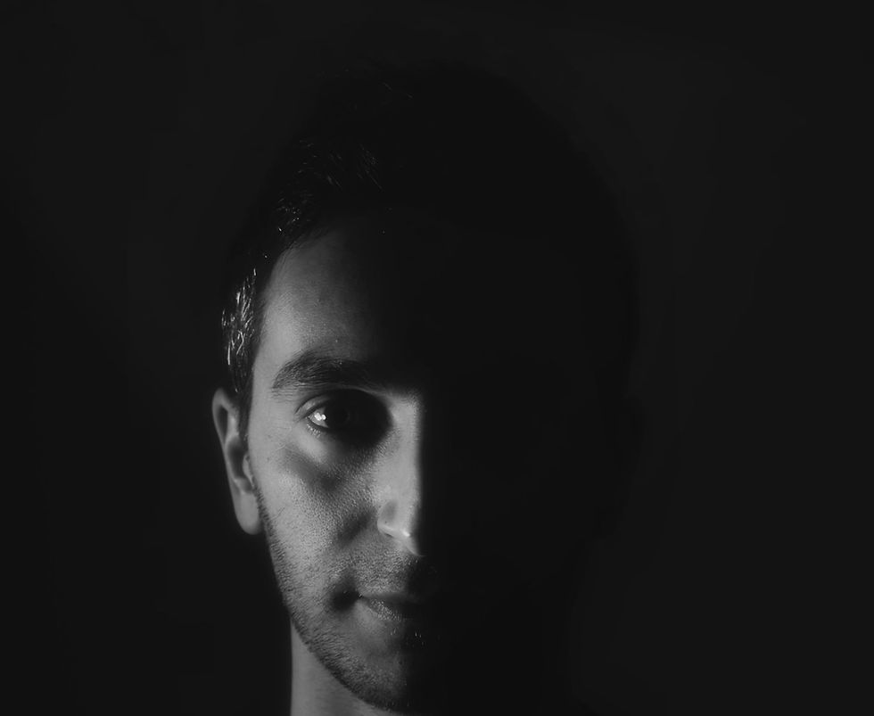 Italian DJ and producer INVE of Inve and Forsi in a dark themed headshot with right side of face visible, black and white image..