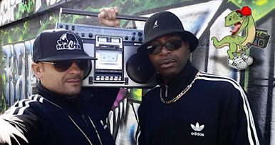 French DJs and producers G-Zon and Ronsha  standing in a street in Paris with graffiti behind them and a ghetto Blaster on G-Zons' and Ronshas' shoulder both wearing sunglasses, colour image.