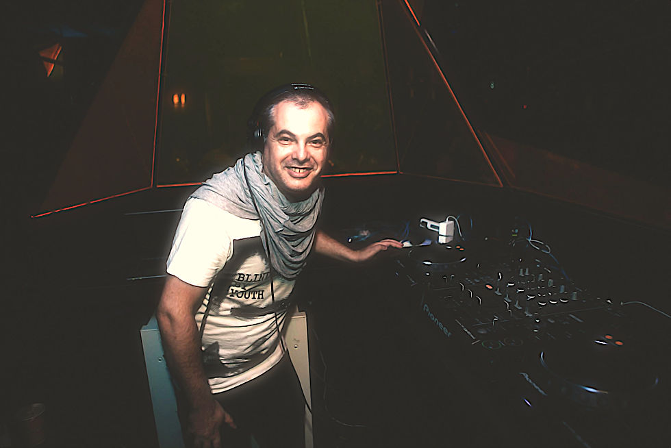 Italian DJ and producer Marco Mei at Ciao Taipei on decks smiling at camera, colour image.