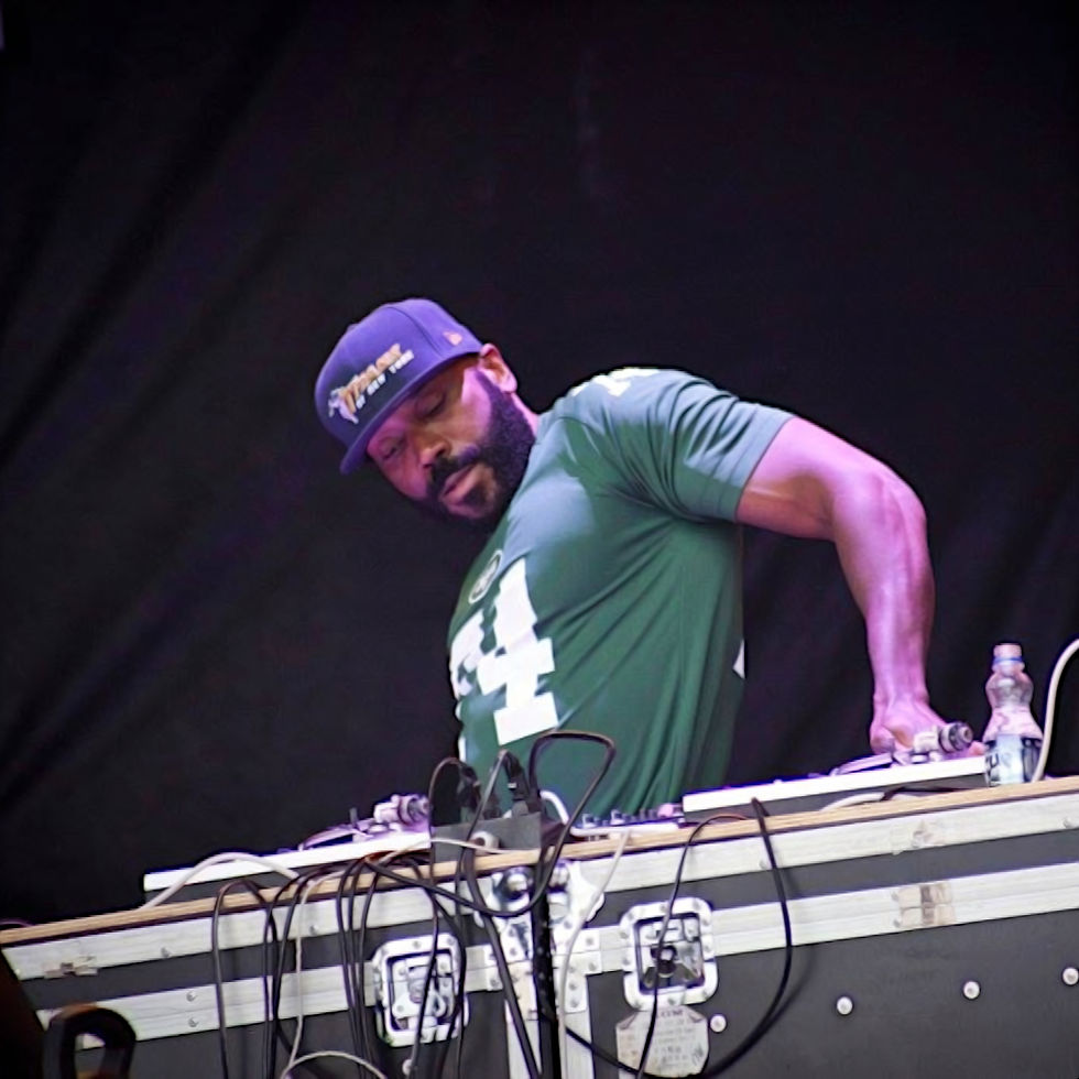 American DJ and producer Rob Swift performing on Technics SL-1200s at an event wearing a baseball cap and green T-shirt, colour image