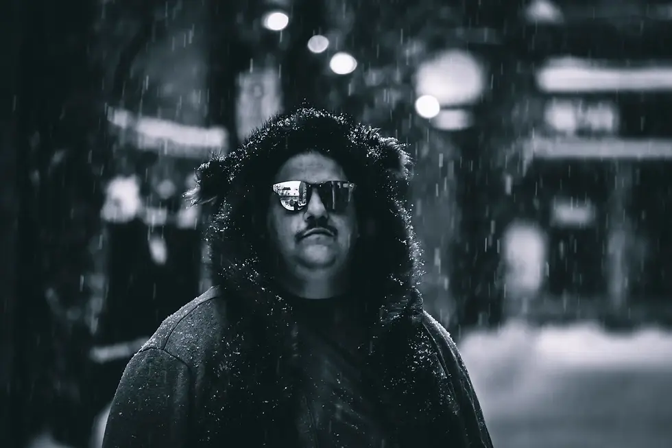 Black-and-white portrait of Canadian DJ Spiritual Viking, also known as Trevor Peterson, wearing sunglasses in the snow, representing his Techno sound and Montreal club background.