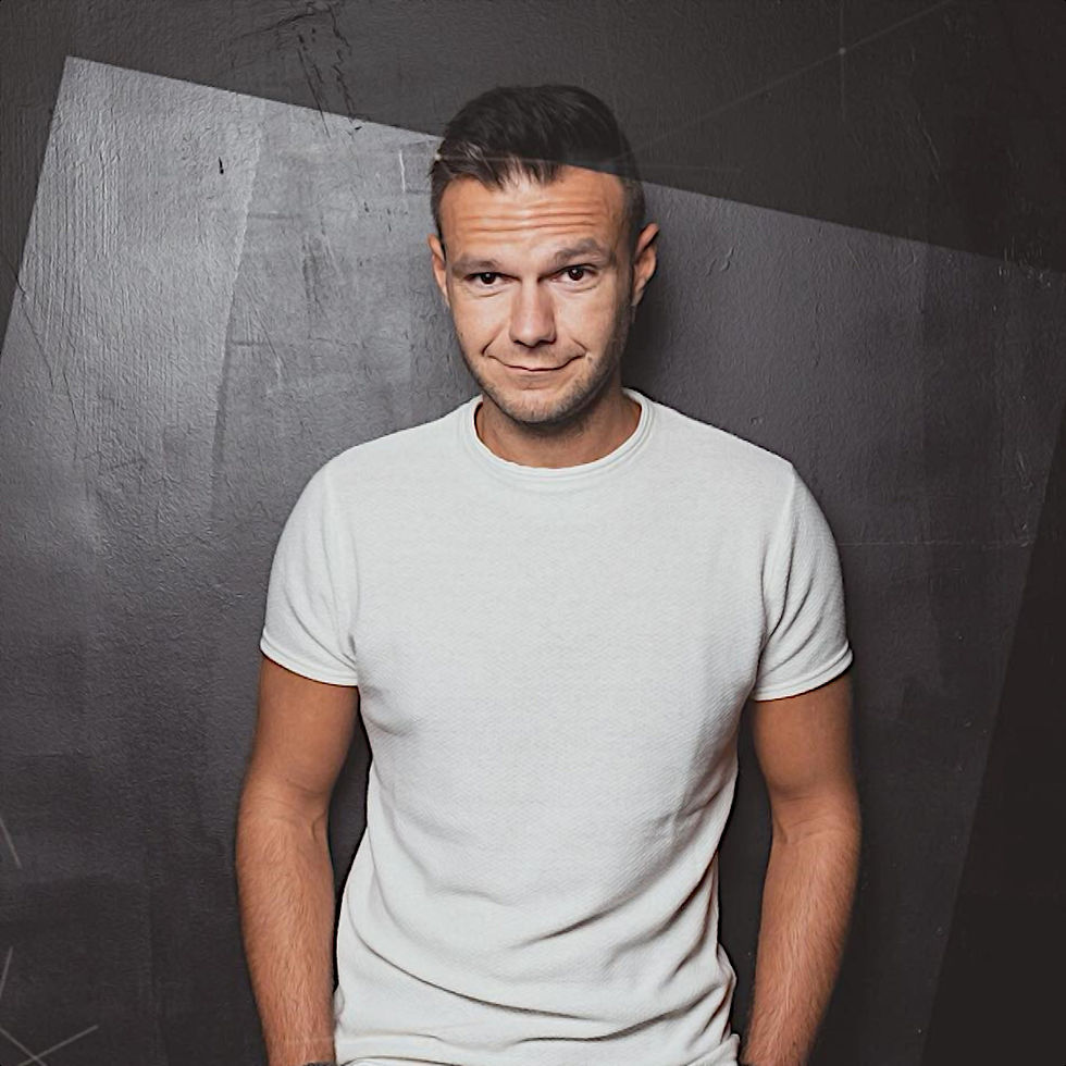 Italian DJ and Producer Andrea Mirgone standing looking at cameraman with his hands in his pockets, colour image.