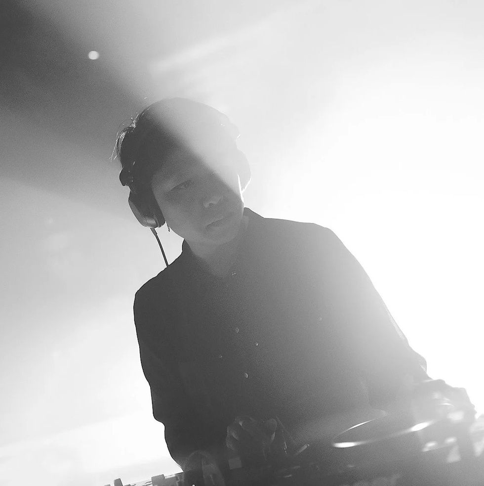 Singaporean DJ EJ Missy performing at an event, black and white image.