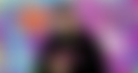 French DJ Phoenixx standing in a street with  wall covered in Graffiti and a caption Never Stop Creating, colour image.