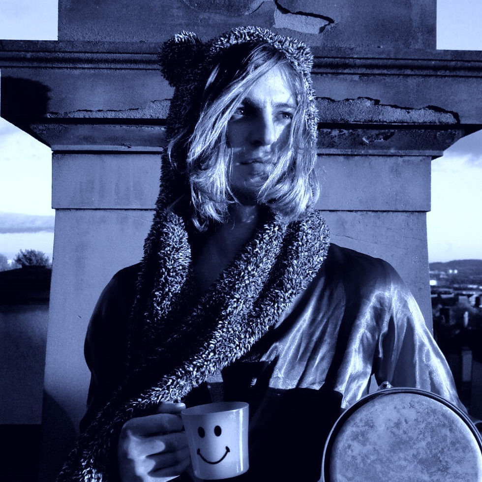 British DJ and producer Ezmun standing in front of monument holding a tea cup, black and white image with blue tinge.