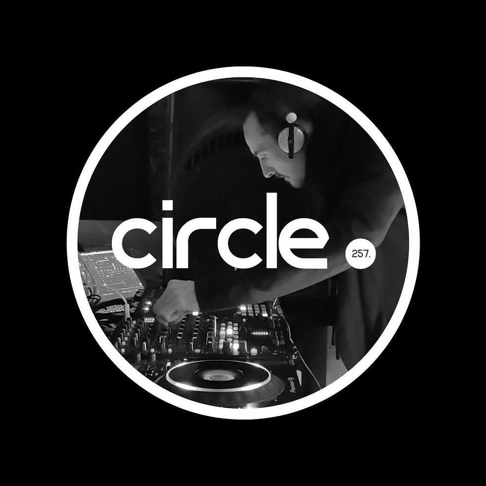 Pete Bidwell performing as a DJ behind circle. 257 logo.
