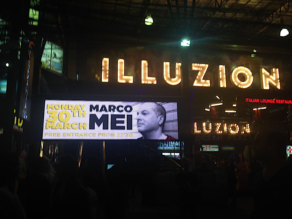 Italian DJ and producer Marco Mei on a billboard outside Illuzion nightclub, colour image.