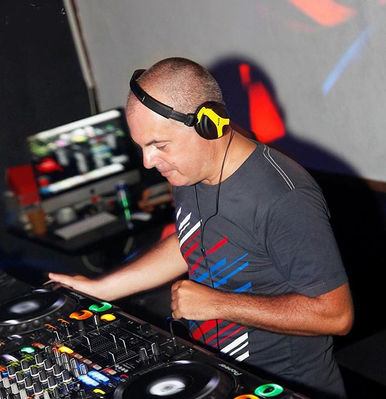Italian DJ and producer Marco Mei performing at an event in an angled picture taken from his left side, colour image
