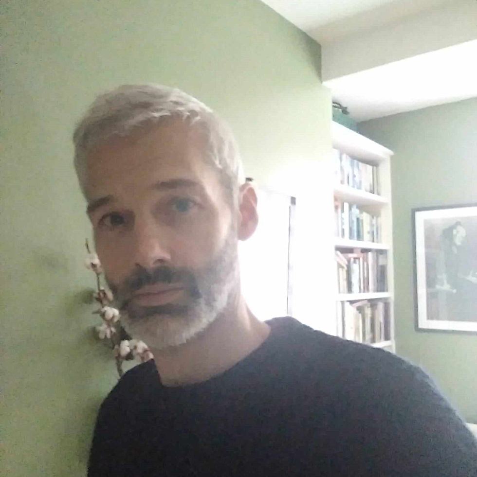 British DJ and producer Skin Teeth standinmg looking at camera in his living room, colour image.