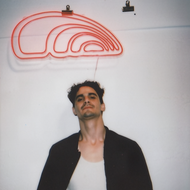 New Orleans DJ and producer Cal LikeRipken pictured in a promotional portrait beneath neon artwork.